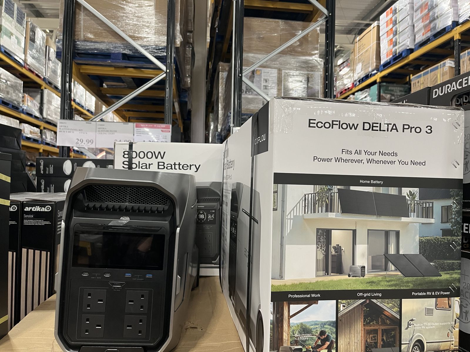 EcoFlow DELTA Pro 3 solar battery on a pallet in a UK Costco warehouse, boxed as 8000W Solar Battery with a UK 3-pin unit in front