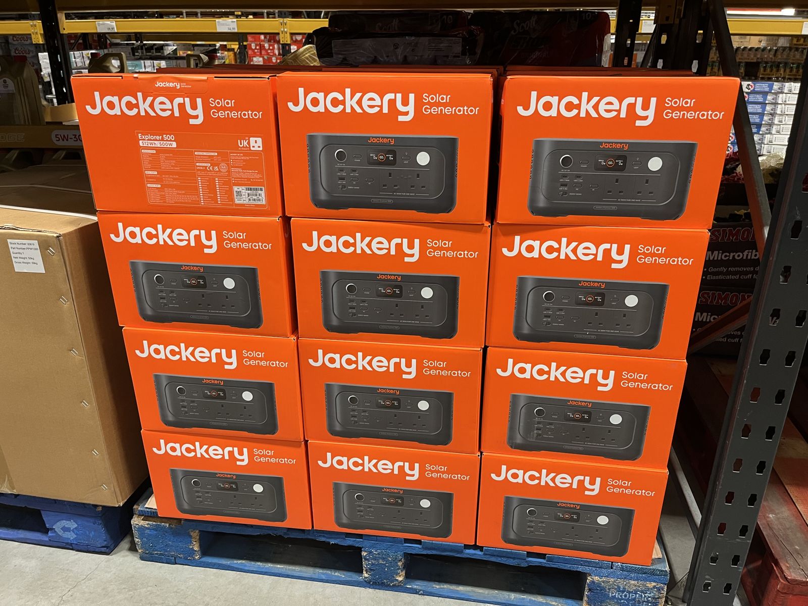 A full pallet of Jackery Explorer 500 solar generators in UK Costco, twelve orange boxes stacked with UK AC output