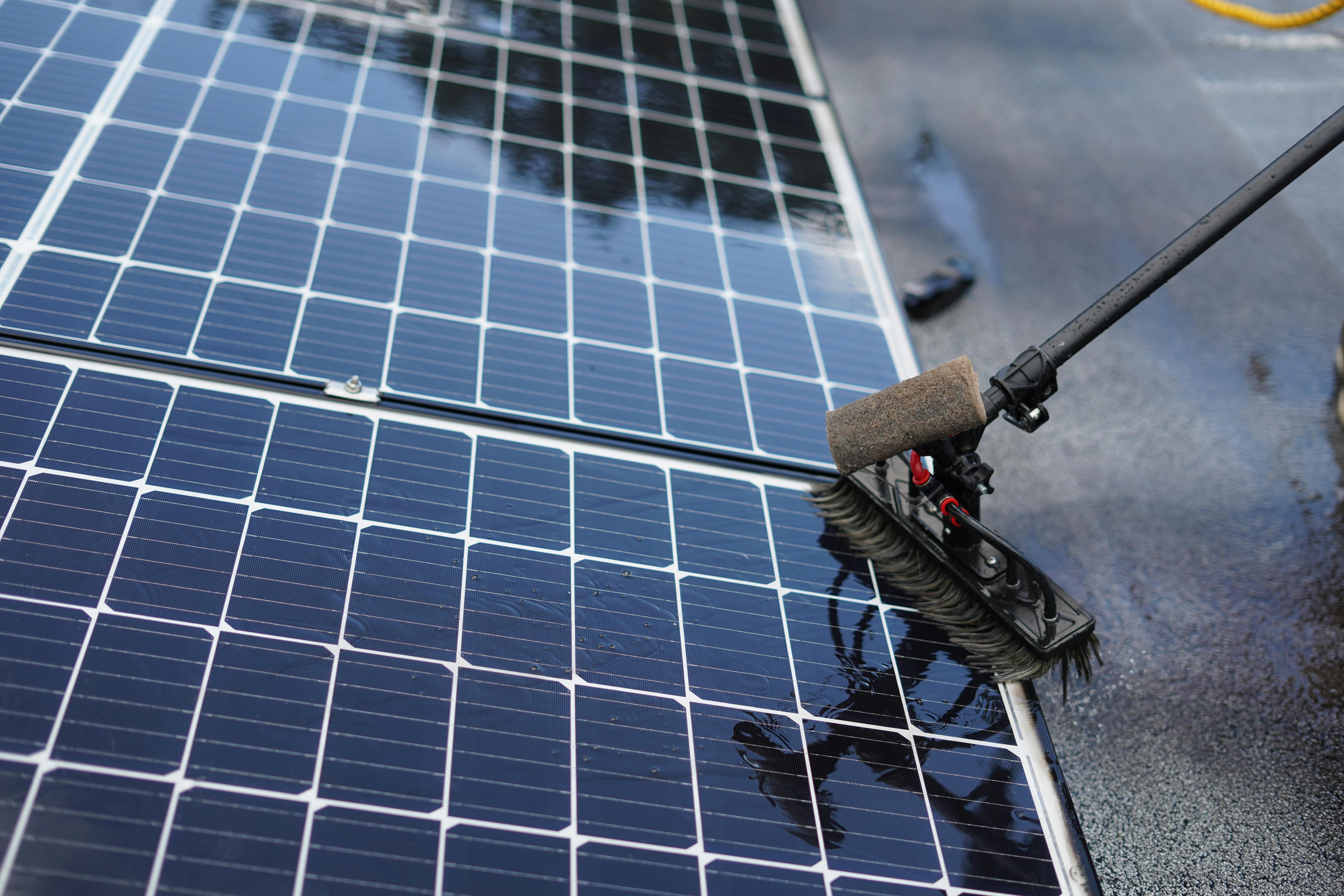 Solar panels being cleaned with water - simple maintenance that keeps plug-in solar systems running at peak performance