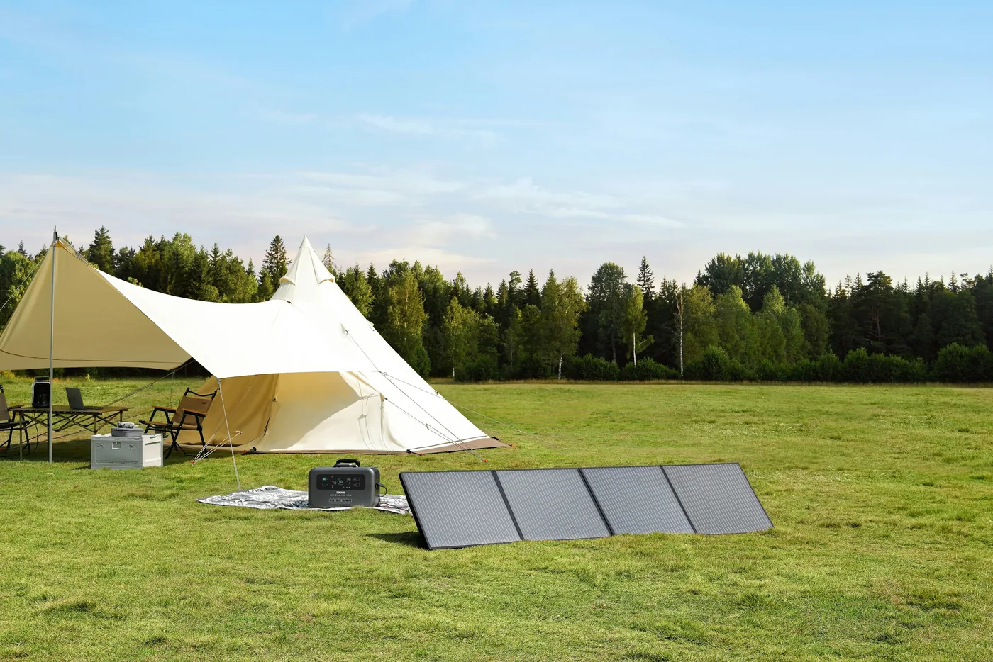 Portable solar panel and power station set up outdoors beside a tent